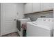 Laundry room with a washer, dryer, and overhead cabinets for easy storage at 18836 Maisons Dr, Lutz, FL 33558