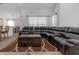 Inviting living room with a large sectional sofa, coffee table, and open layout to the dining area at 18836 Maisons Dr, Lutz, FL 33558