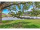A beautiful pond view with the calm water and green trees in the backyard creates a serene and peaceful atmosphere at 18836 Maisons Dr, Lutz, FL 33558