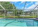 A pool is enclosed in a screen with a view of the lake at 18836 Maisons Dr, Lutz, FL 33558