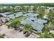 Aerial view of well-maintained tennis courts with lush landscaping and ample parking at 18836 Maisons Dr, Lutz, FL 33558