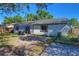 The backyard showcases a garden, small patio and grassy area, enclosed by a wooden fence and mature trees at 1915 Peppertree Dr, Oldsmar, FL 34677