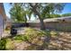 Spacious backyard with a patio area, mature tree, and wood fence at 1915 Peppertree Dr, Oldsmar, FL 34677