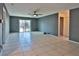 Large, open living room with tile flooring, ceiling fan, and sliding glass doors providing access to outdoor area at 1915 Peppertree Dr, Oldsmar, FL 34677