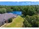 Aerial view of the backyard with a screened lanai overlooking a lake and mature trees at 19194 Lake Audubon Dr, Tampa, FL 33647