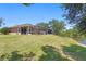 Spacious backyard featuring a screened patio, lush lawn, and a tranquil lake view at 19194 Lake Audubon Dr, Tampa, FL 33647