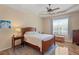 Cozy bedroom featuring a wooden bed frame, ceiling fan, wood floors, and a bright window at 19194 Lake Audubon Dr, Tampa, FL 33647