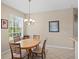 Cozy dining area featuring a wooden table, chandelier lighting, and a bright window at 19194 Lake Audubon Dr, Tampa, FL 33647