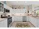 Bright kitchen featuring white cabinets, tile floors, and modern appliances at 19194 Lake Audubon Dr, Tampa, FL 33647