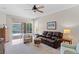Comfortable living room with a ceiling fan and a sliding glass door to the screened patio at 19194 Lake Audubon Dr, Tampa, FL 33647