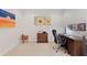 Spacious office boasts sunflower art above wooden desk and chair on light carpet at 19194 Lake Audubon Dr, Tampa, FL 33647