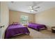 Neutral bedroom with two twin beds, ceiling fan and ample sunlight filtering through the window at 20117 Indian Rosewood Dr, Tampa, FL 33647