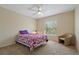 Cozy bedroom featuring a ceiling fan, window with blinds, and a comfortable armchair at 20117 Indian Rosewood Dr, Tampa, FL 33647