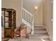 Inviting hallway features staircase with neutral carpeting and a charming accent chair nearby at 20117 Indian Rosewood Dr, Tampa, FL 33647
