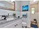 Clean bathroom with a modern vanity, decorative mirror, white tile, and updated fixtures at 2054 Deerwood Rd, Seffner, FL 33584