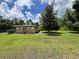 Single-story brick home featuring a large, grassy lawn and complemented by mature trees at 2054 Deerwood Rd, Seffner, FL 33584