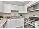 Modern kitchen with stainless steel appliances, granite countertops, and white cabinets at 2054 Deerwood Rd, Seffner, FL 33584