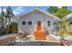 Back exterior showcasing newly painted gray wood siding and bright orange door and stairs at 220 19Th S Ave, St Petersburg, FL 33705