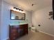 Bathroom features a dark wood vanity with green glass countertop, decorative mirror, and tiled floors at 2333 Feather Sound Dr # B104, Clearwater, FL 33762