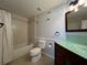Bathroom featuring a bathtub, glass countertop vanity, and tiled walls around the tub at 2333 Feather Sound Dr # B104, Clearwater, FL 33762