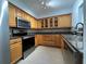 Kitchen featuring stainless steel appliances, custom cabinets, granite countertops, tile flooring, and track lighting at 2333 Feather Sound Dr # B104, Clearwater, FL 33762