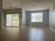 Light-filled living room with tile flooring, neutral paint, sliding door to balcony, and window with bright, natural light at 2333 Feather Sound Dr # B104, Clearwater, FL 33762