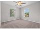 Neutral bedroom featuring plush carpeting, a ceiling fan, and dual windows at 246 Castlekeeper Pl, Valrico, FL 33594