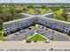Aerial view of a meticulously maintained condo building with ample parking and lush green surroundings at 2469 Franciscan Dr # 19, Clearwater, FL 33763