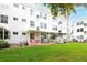 Back exterior view of the building with patios and a large, grassy common area at 2469 Franciscan Dr # 19, Clearwater, FL 33763