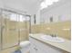 Bathroom featuring a glass enclosed shower, sink, and a neutral-toned tile at 2469 Franciscan Dr # 19, Clearwater, FL 33763