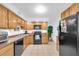 Well-lit kitchen featuring oak cabinets, tiled floors, and essential modern appliances at 2469 Franciscan Dr # 19, Clearwater, FL 33763