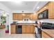 A well-lit kitchen featuring wooden cabinets and modern black appliances at 2469 Franciscan Dr # 19, Clearwater, FL 33763
