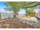 Large backyard featuring a fire pit, green trees, and partial fencing at 2616 Ohio Pl, Holiday, FL 34691