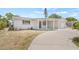 Charming white brick home featuring a covered front porch and an attached garage at 2616 Ohio Pl, Holiday, FL 34691