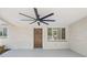 Covered porch with a ceiling fan, wood door, white brick, and large windows at 2616 Ohio Pl, Holiday, FL 34691