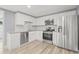 Modern kitchen with stainless steel appliances, white cabinets, granite countertops, and subway tile backsplash at 2616 Ohio Pl, Holiday, FL 34691