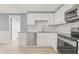 Well-lit kitchen featuring white cabinetry, stainless steel appliances and white subway tile backsplash at 2616 Ohio Pl, Holiday, FL 34691
