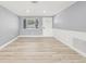 Inviting living room featuring wainscoting, modern flooring, and a view of the front yard at 2616 Ohio Pl, Holiday, FL 34691