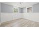 Well-lit room with wood-look floors, neutral paint, wainscoting, and two windows at 2616 Ohio Pl, Holiday, FL 34691