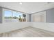 Bright room with large windows showcasing a serene outdoor view and light wood-look flooring at 2616 Ohio Pl, Holiday, FL 34691