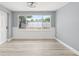 Bright room with large window overlooking fenced backyard, wood-look flooring, and neutral paint at 2616 Ohio Pl, Holiday, FL 34691