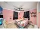 ' bedroom with pink walls, laminate flooring, ceiling fan, shelving, and decorative accents for fun, functional space at 3422 Trask Dr, Holiday, FL 34691