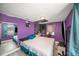 Unique bedroom design with purple walls, laminate flooring, an accent wall, and a cozy sleeping area at 3422 Trask Dr, Holiday, FL 34691