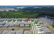 An aerial view of a neighborhood featuring modern homes and a tranquil pond in the backdrop at 34780 Rainville Loop, Zephyrhills, FL 33541