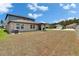 Spacious backyard with a covered patio, offering serene views of the surrounding neighborhood at 34780 Rainville Loop, Zephyrhills, FL 33541