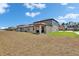 Backyard view of a home with a covered patio, showcasing the exterior and green space at 34780 Rainville Loop, Zephyrhills, FL 33541