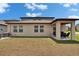 View of the home's backyard, including a covered patio area with outdoor furniture at 34780 Rainville Loop, Zephyrhills, FL 33541