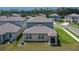 Aerial view of the home's backyard with a small patio, landscaped yard, and well-maintained lawn at 34780 Rainville Loop, Zephyrhills, FL 33541