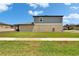 Exterior home view from the backyard featuring a spacious lawn and neighborhood landscape at 34780 Rainville Loop, Zephyrhills, FL 33541