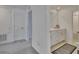 Bathroom with double sinks, white cabinets, shower, and wood-look tile flooring at 34780 Rainville Loop, Zephyrhills, FL 33541